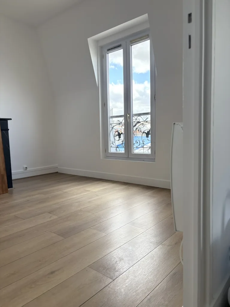 Après travaux : pièce blanche, parquet, fenêtre sur les toits